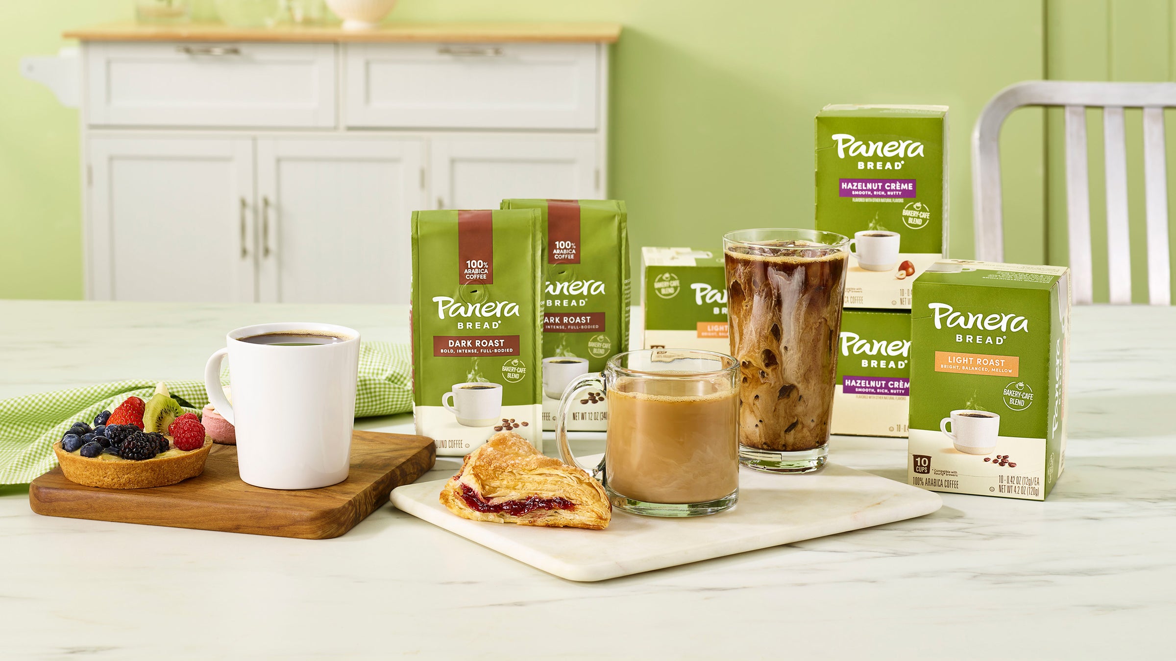 panera ground coffee and single serve products on table with food breakfast and cups in the foreground