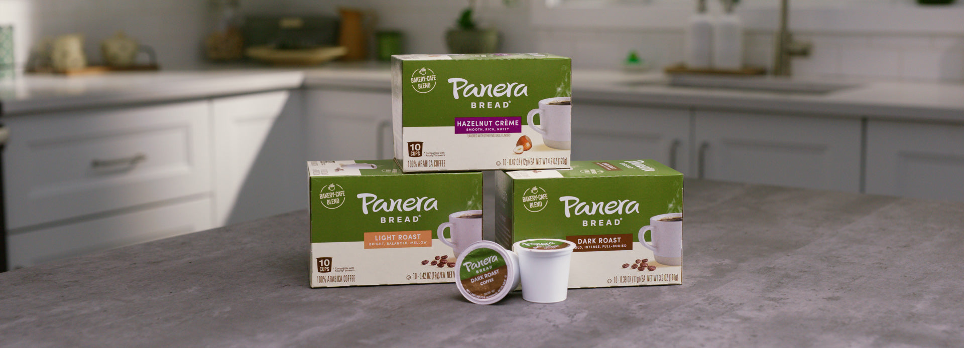 panera green carton trio stacked on kitchen table with single serve pods in front
